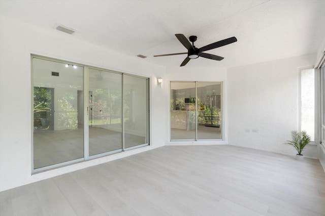 unfurnished sunroom with ceiling fan