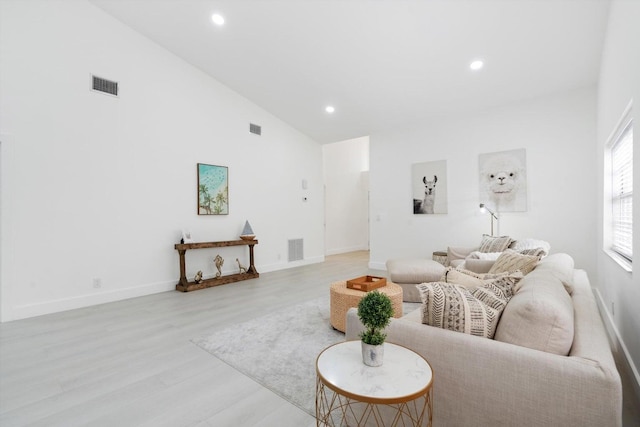 living room featuring light hardwood / wood-style flooring and high vaulted ceiling