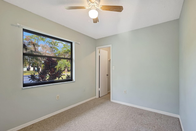 unfurnished room featuring light carpet and ceiling fan