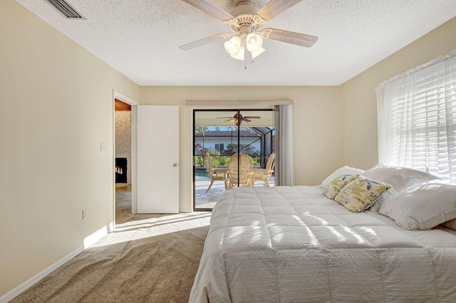 carpeted bedroom featuring ceiling fan, a high end fireplace, a textured ceiling, and access to outside