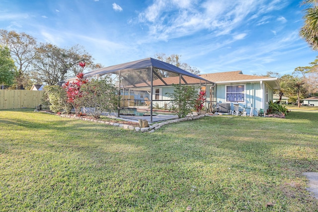 back of house featuring a lawn and glass enclosure