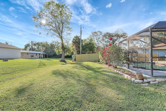 view of yard with a lanai and a swimming pool