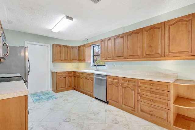 kitchen featuring appliances with stainless steel finishes, sink, and a textured ceiling