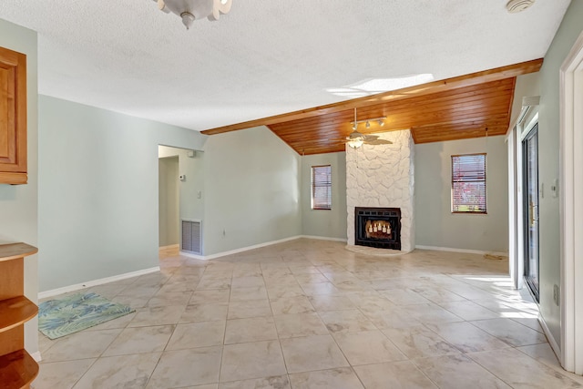 unfurnished living room featuring lofted ceiling, a stone fireplace, heating unit, wooden ceiling, and ceiling fan