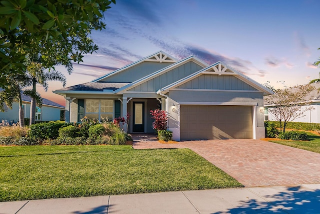 craftsman-style house featuring a garage and a yard