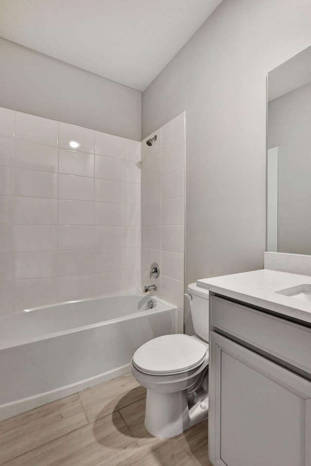 full bathroom featuring hardwood / wood-style flooring, vanity,  shower combination, and toilet