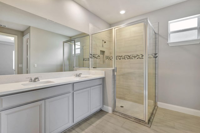 bathroom with a shower with door and vanity