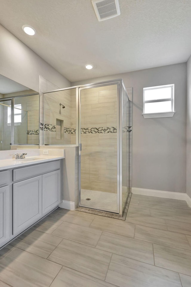 bathroom featuring vanity and an enclosed shower