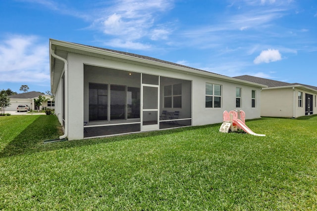 back of house with a lawn and a sunroom