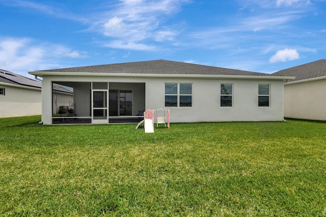 back of property featuring a lawn and a sunroom