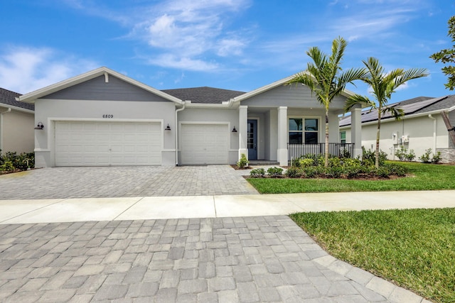 single story home featuring covered porch and a garage