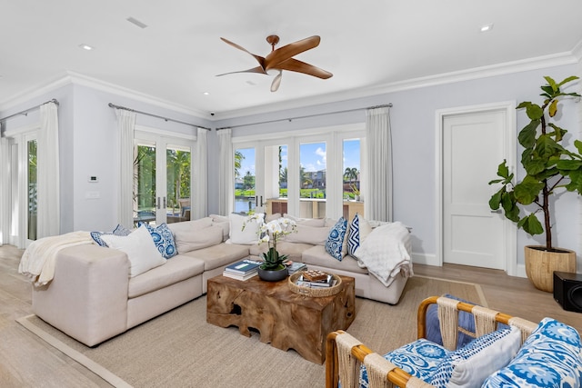 living room featuring light wood-type flooring, ceiling fan, and crown molding