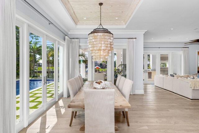 dining space with plenty of natural light, light hardwood / wood-style floors, ornamental molding, and an inviting chandelier