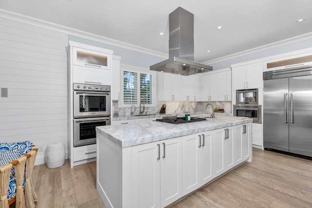 kitchen featuring a center island, stainless steel appliances, white cabinetry, and island range hood