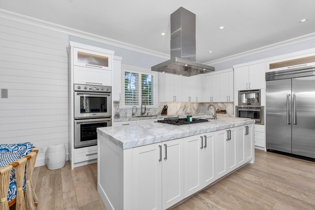 kitchen with white cabinetry, island exhaust hood, and appliances with stainless steel finishes