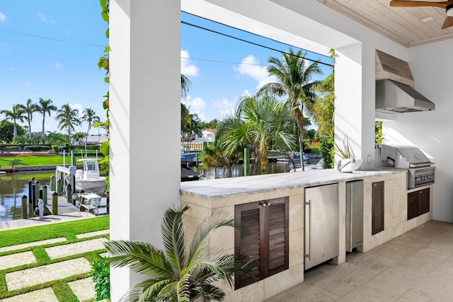 view of patio / terrace with a dock, exterior bar, ceiling fan, a water view, and grilling area