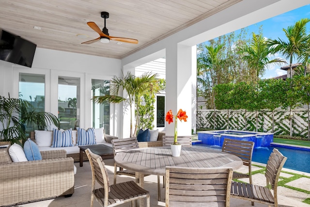 view of patio / terrace with outdoor lounge area, a swimming pool with hot tub, pool water feature, and ceiling fan