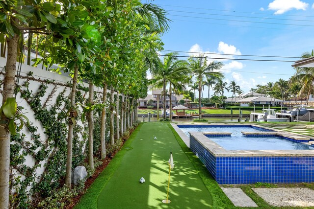 view of swimming pool featuring an in ground hot tub and a water view