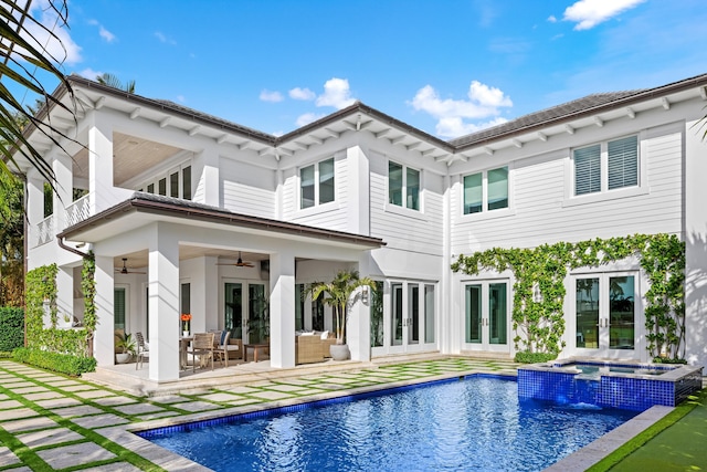 back of house featuring ceiling fan, french doors, a pool with hot tub, an outdoor hangout area, and a patio