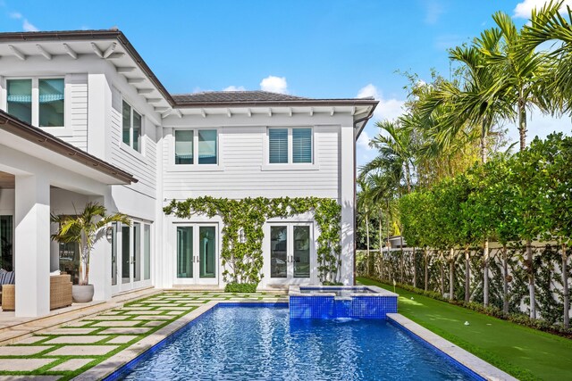 rear view of house with ceiling fan, french doors, pool water feature, a patio area, and a swimming pool with hot tub