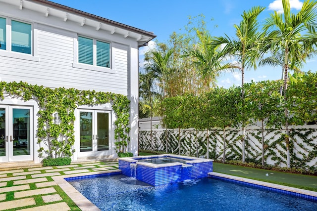 view of pool featuring pool water feature, an in ground hot tub, and french doors