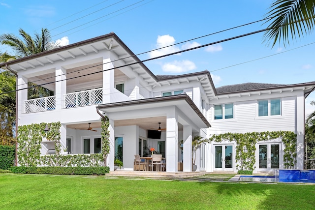 rear view of house featuring a yard, a patio area, ceiling fan, and a balcony