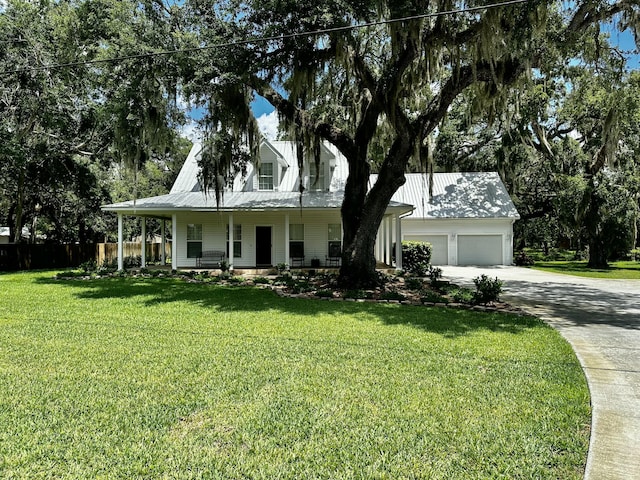 view of front of property featuring a front yard, a garage, and covered porch