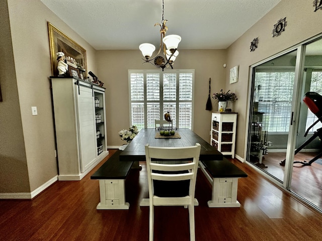 dining space with dark hardwood / wood-style floors, a textured ceiling, and a chandelier