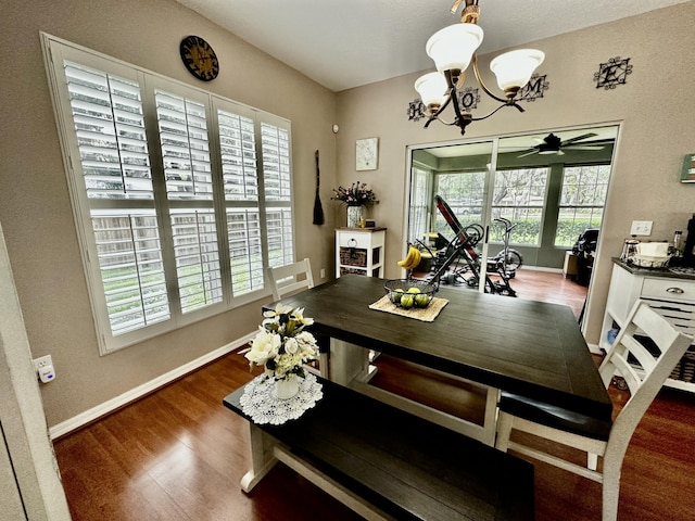 dining room with ceiling fan with notable chandelier, a healthy amount of sunlight, and dark wood-type flooring