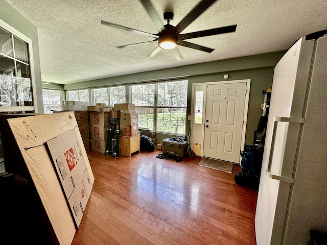 miscellaneous room with ceiling fan, wood-type flooring, and a textured ceiling