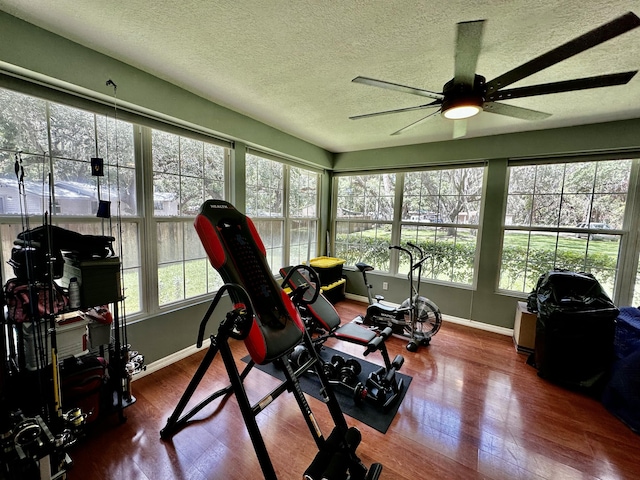 exercise area with ceiling fan, plenty of natural light, a textured ceiling, and hardwood / wood-style flooring