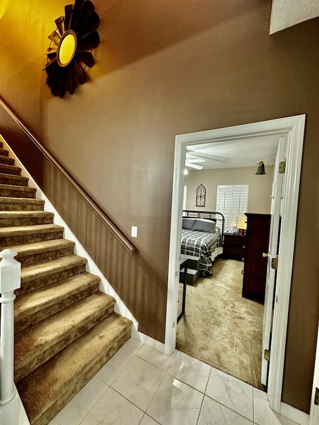 stairs featuring tile patterned flooring and ceiling fan