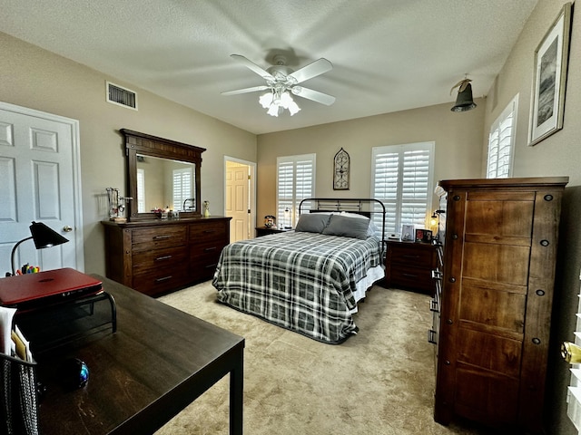 carpeted bedroom with a textured ceiling and ceiling fan