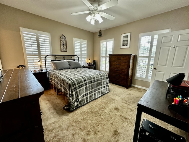 carpeted bedroom with ceiling fan and multiple windows