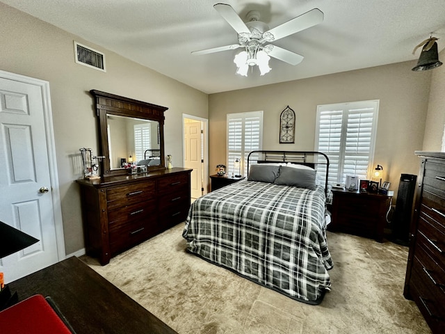 bedroom with multiple windows, ceiling fan, and light colored carpet