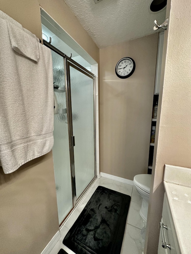 bathroom featuring toilet, a textured ceiling, tile patterned floors, and a shower with door