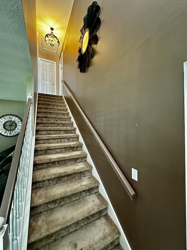 stairs with a textured ceiling