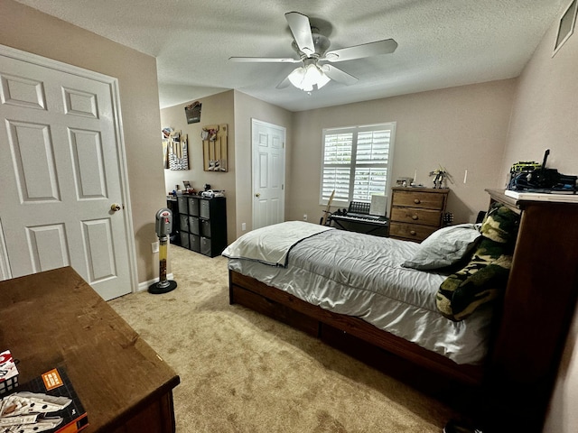 bedroom with a textured ceiling, light colored carpet, and ceiling fan