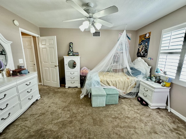 carpeted bedroom with ceiling fan and a textured ceiling