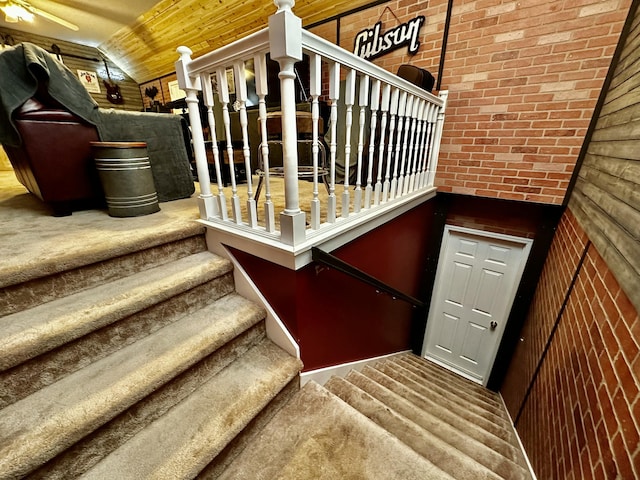 staircase with carpet, lofted ceiling, wooden ceiling, and wooden walls