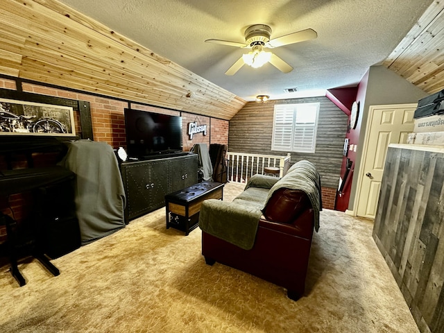 carpeted home theater room featuring brick wall, a textured ceiling, ceiling fan, wooden walls, and lofted ceiling