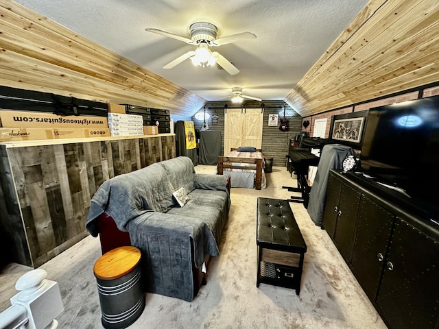 living area with light colored carpet, ceiling fan, wooden walls, a barn door, and lofted ceiling