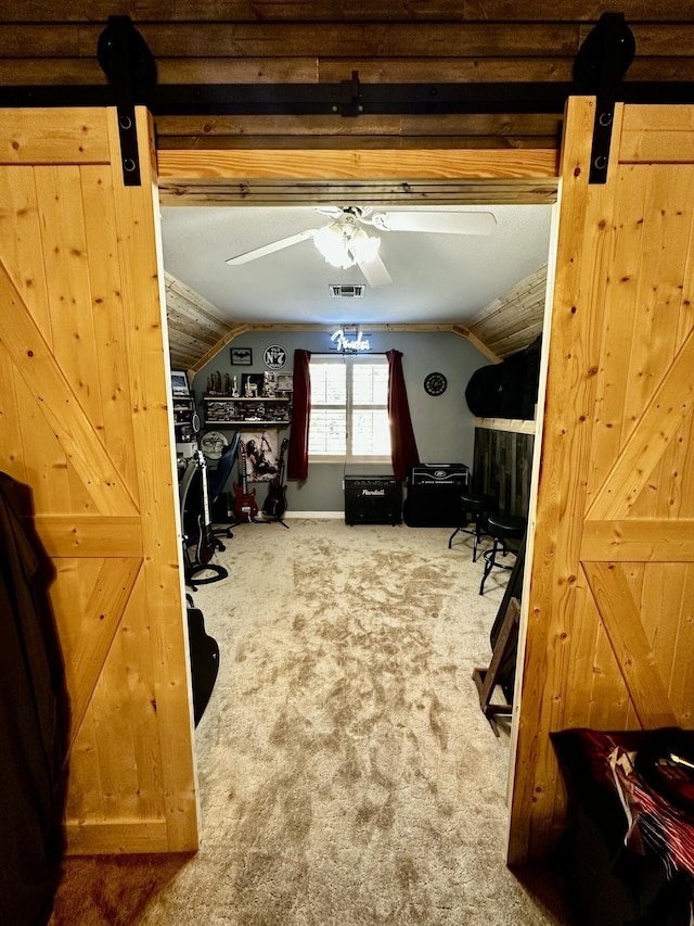 interior space featuring ceiling fan, carpet, and vaulted ceiling