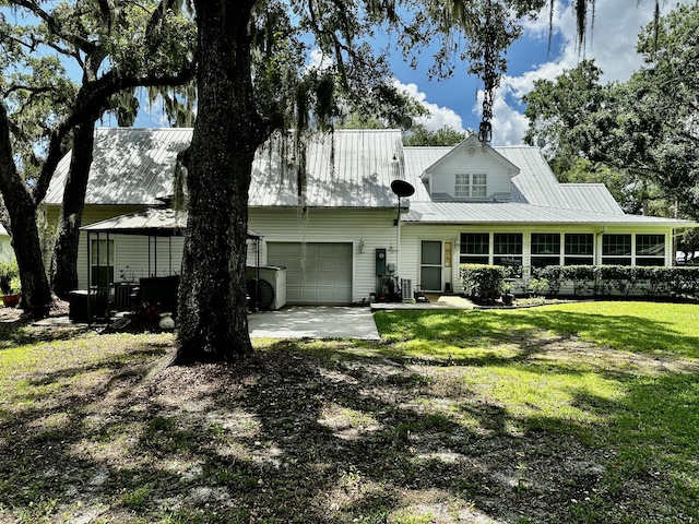 back of property featuring a lawn and a garage