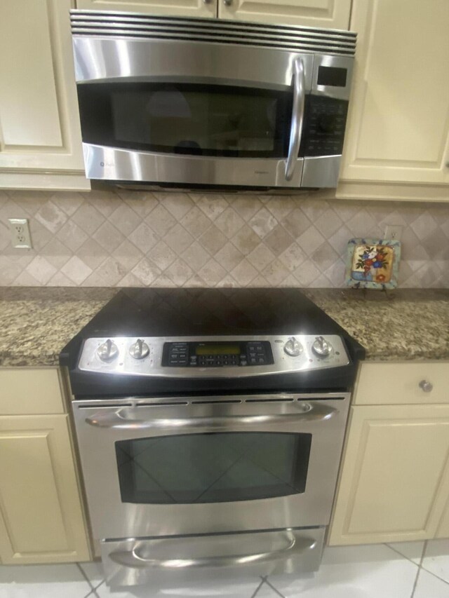 clothes washing area with tile patterned floors and washer / dryer