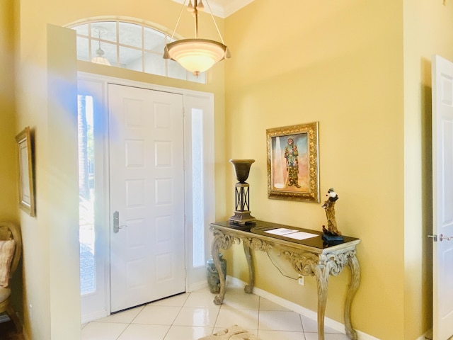 foyer with crown molding, plenty of natural light, and light tile patterned flooring