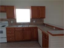 kitchen with white appliances, tasteful backsplash, and sink