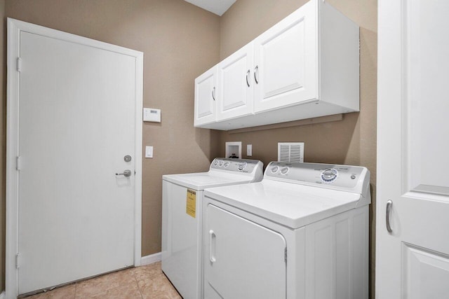 washroom with light tile patterned flooring, cabinets, and separate washer and dryer