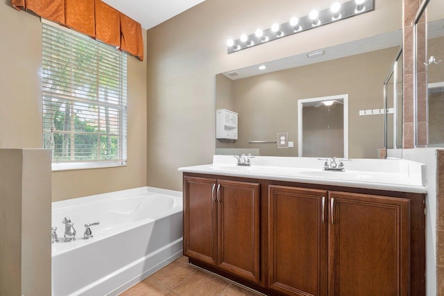 bathroom with tile patterned flooring, a bath, and vanity