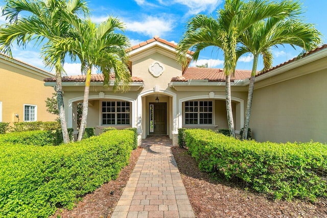 exterior space with a tiled roof and stucco siding